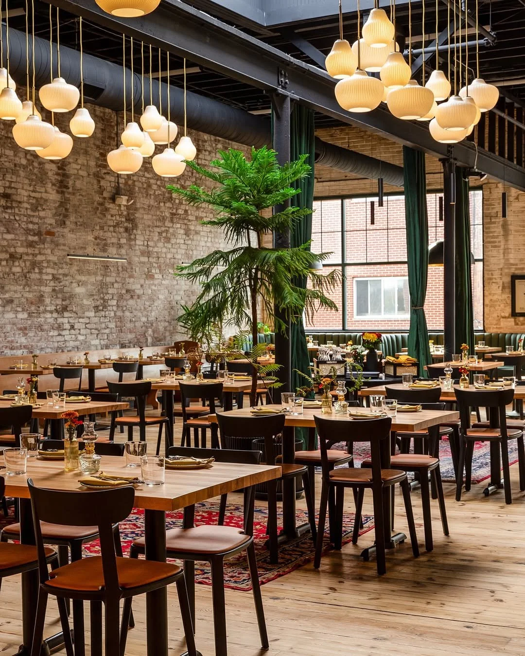 The Capital Dining Room — brick walls, wood tables, globe pendants