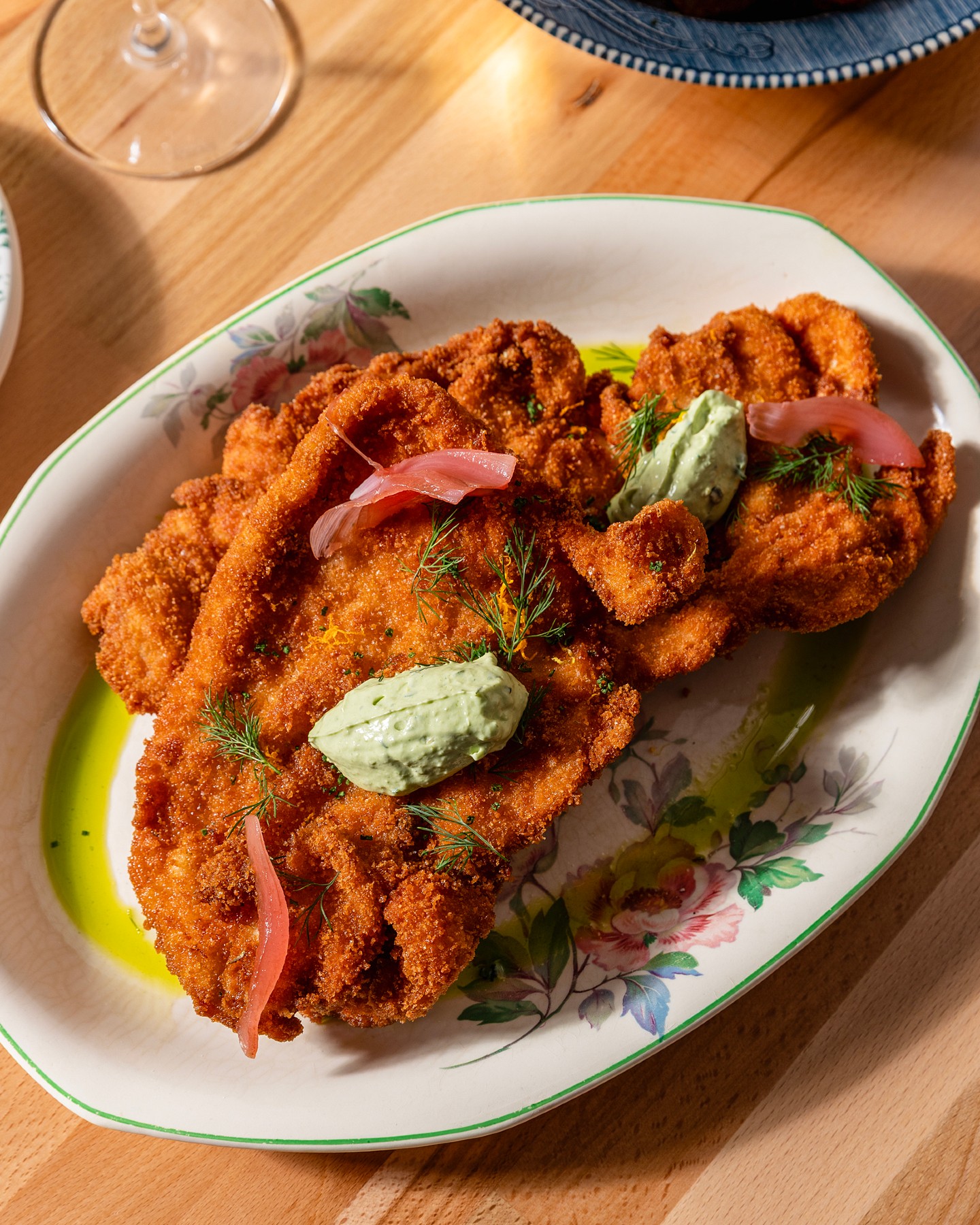 Golden schnitzel with herbed crème and pickled onion