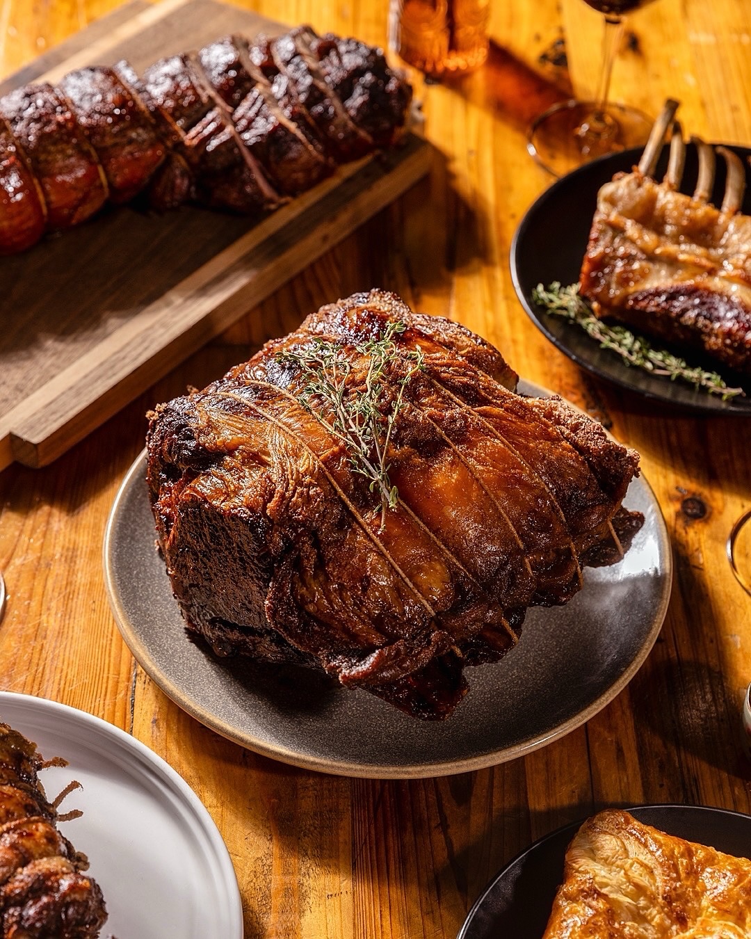 Dry-aged standing rib roast tied with twine, roasted and topped with thyme