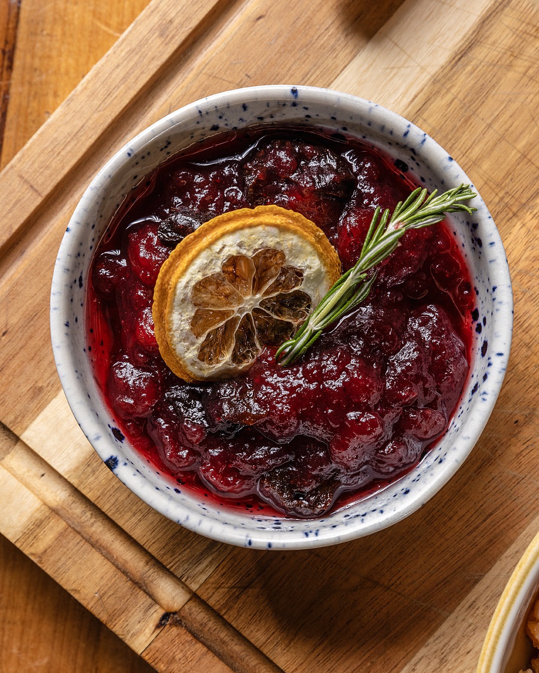 Cranberry sauce topped with a dried lemon slice and rosemary