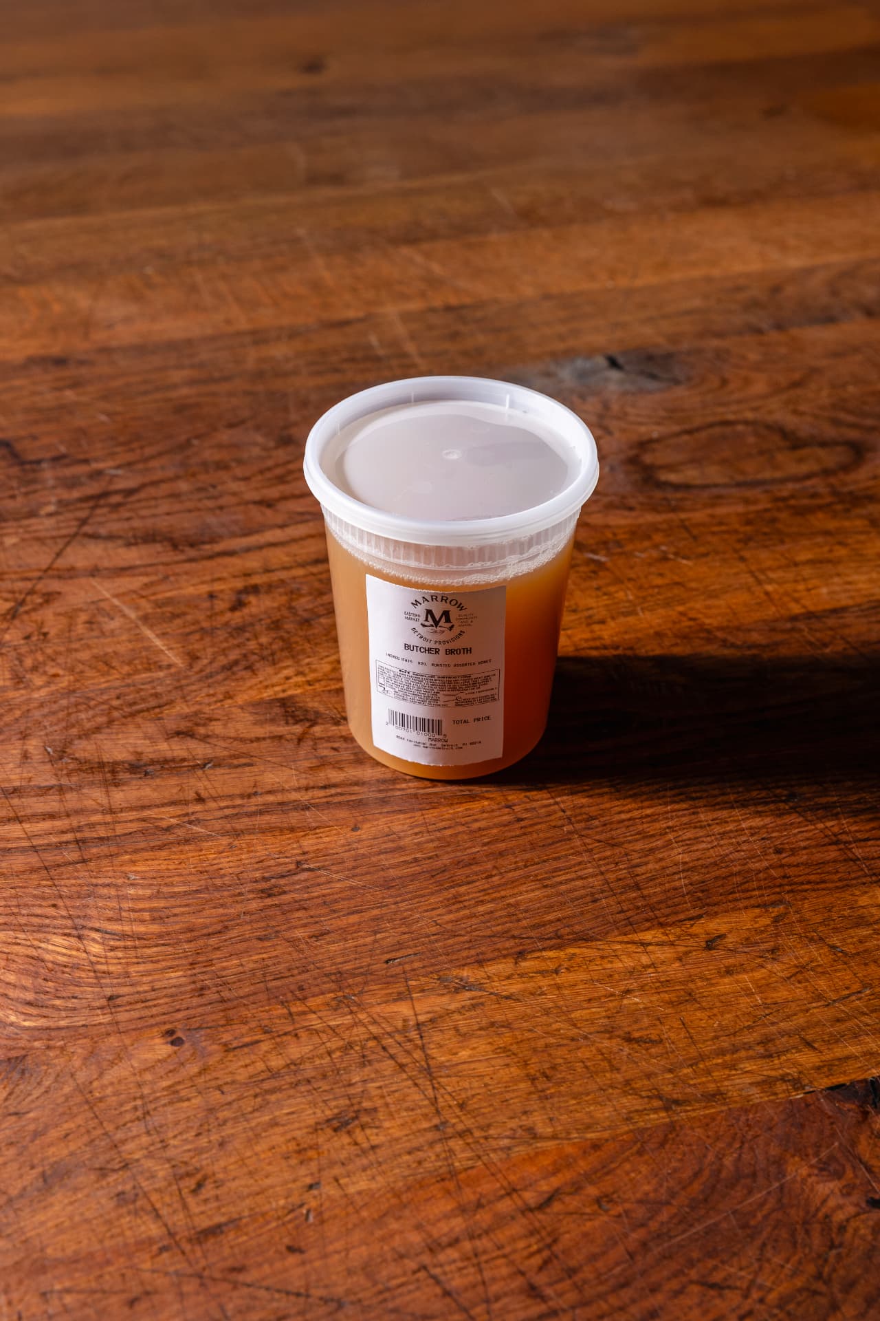Quart container of Marrow stock with a printed label